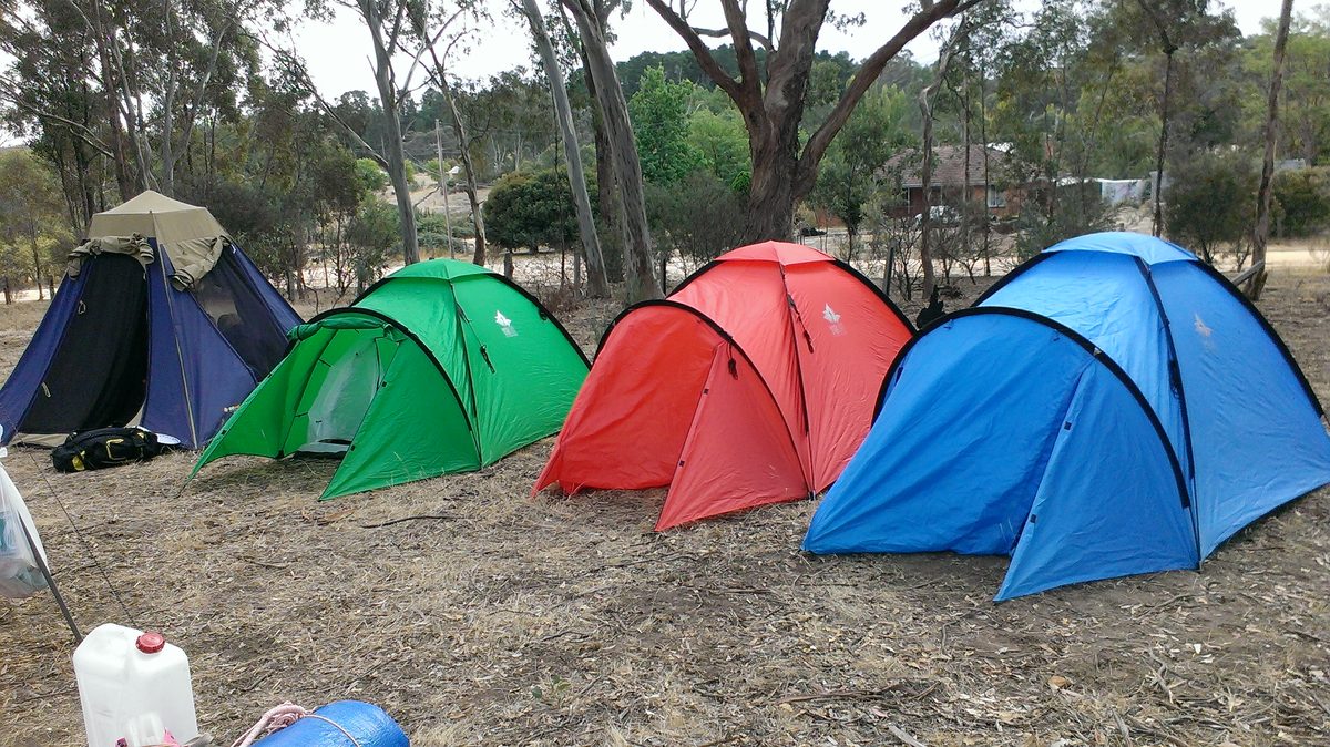 Four colourful tents pitched among the gum trees in the camping ground behind the school